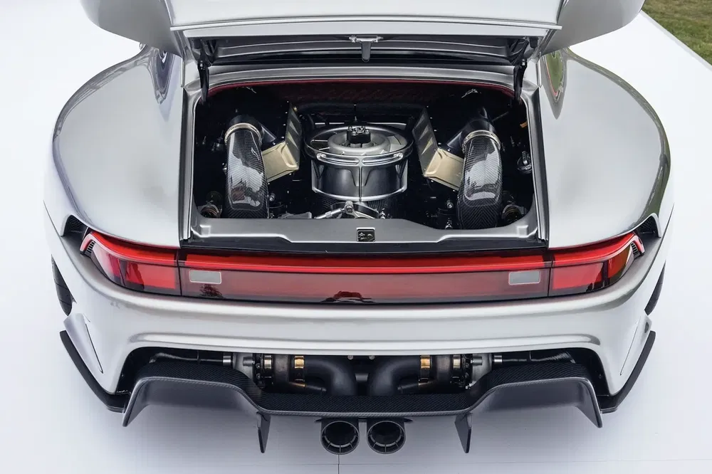 Moderne Porsche achterklep met motor, dubbele uitlaat en aerodynamisch sportief ontwerp.