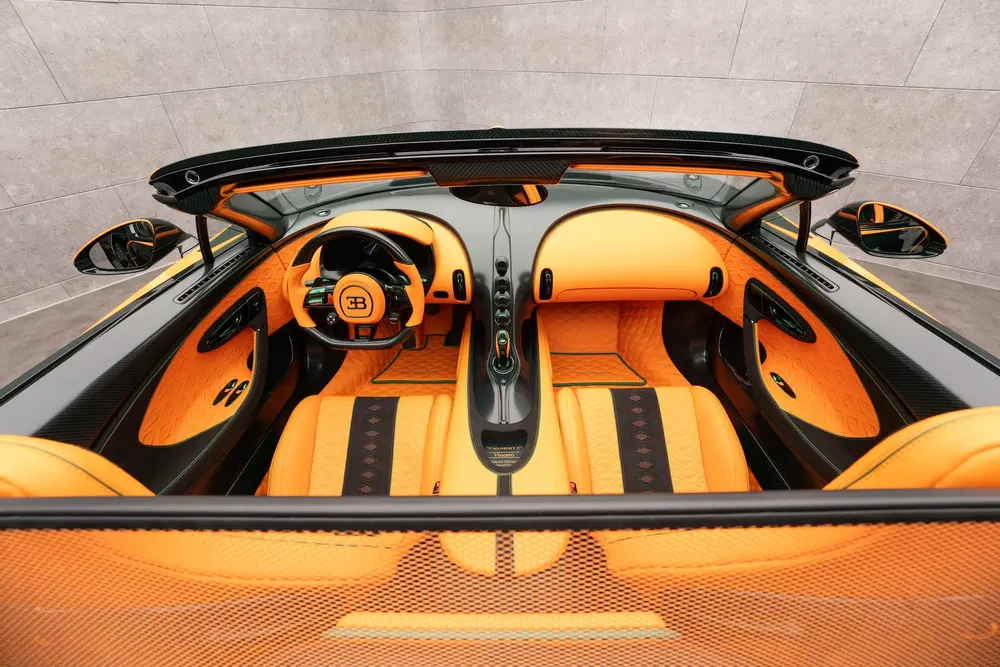Intérieur luxueux de Bugatti avec cuir orange et fibre de carbone noire élégante.