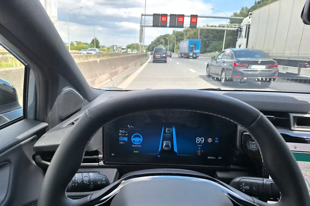 Vue intérieure d'une voiture moderne avec affichage numérique sur une autoroute avec trafic.