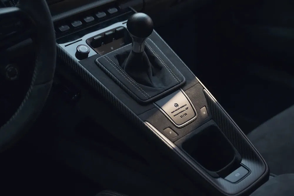 Intérieur de voiture avec levier de vitesse manuel en cuir, finition fibre de carbone.