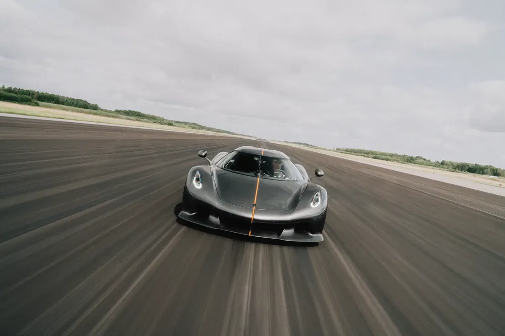 Zwarte Koenigsegg Jesko op de baan, aerodynamisch ontwerp, hoge prestaties.