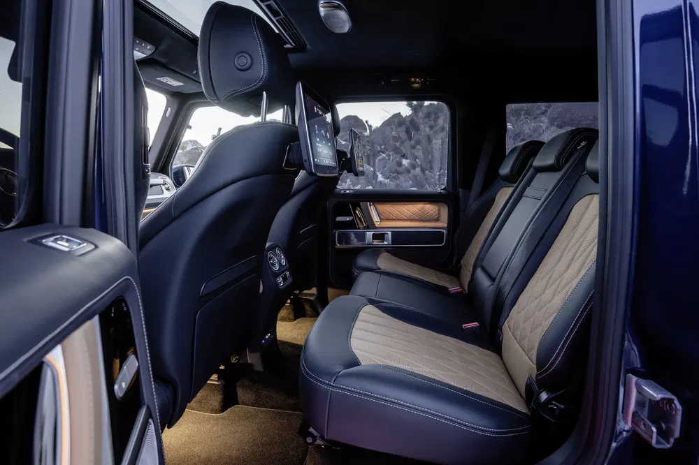 Luxe interieur van de Mercedes-Benz G-Klasse met lederen zetels en ingebouwd scherm.