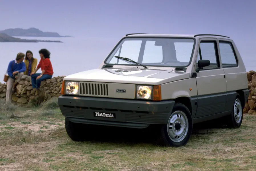 {"fr":"Fiat Panda vintage stationnée près du littoral, personnes en arrière-plan sur un mur en pierre.","nl":"Klassieke Fiat Panda geparkeerd bij de kust, mensen op stenen muur op de achtergrond."}