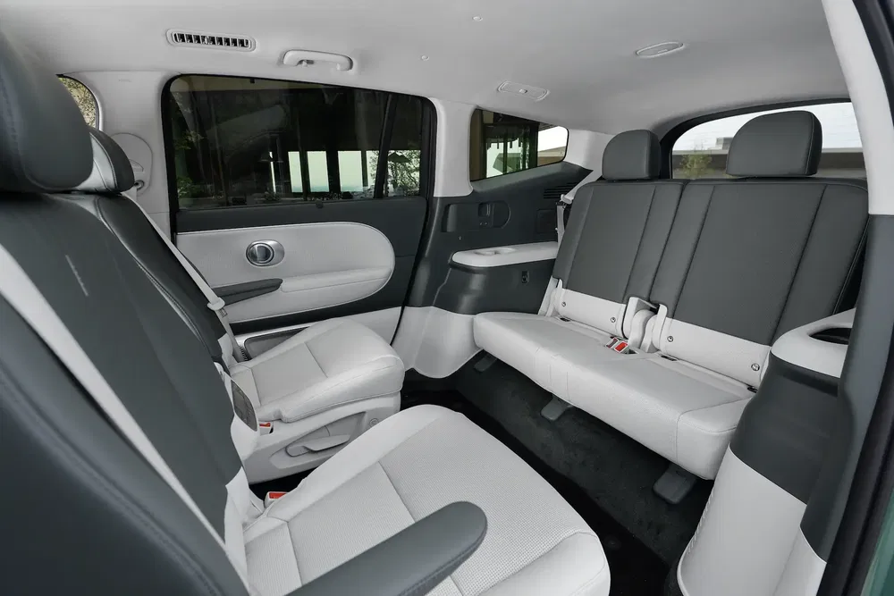 Intérieur spacieux de SUV Hyundai Ioniq 7, sièges en cuir blanc et gris élégants.