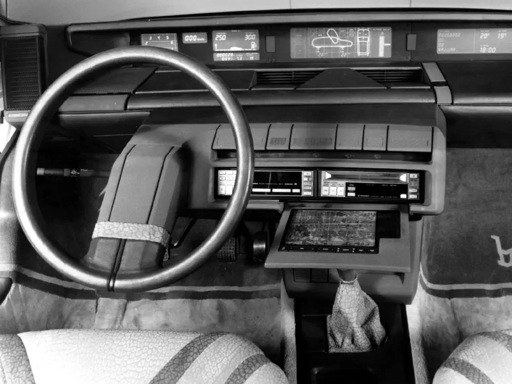 Intérieur de voiture futuriste Citroën CX avec volant unique et tableau de bord numérique.