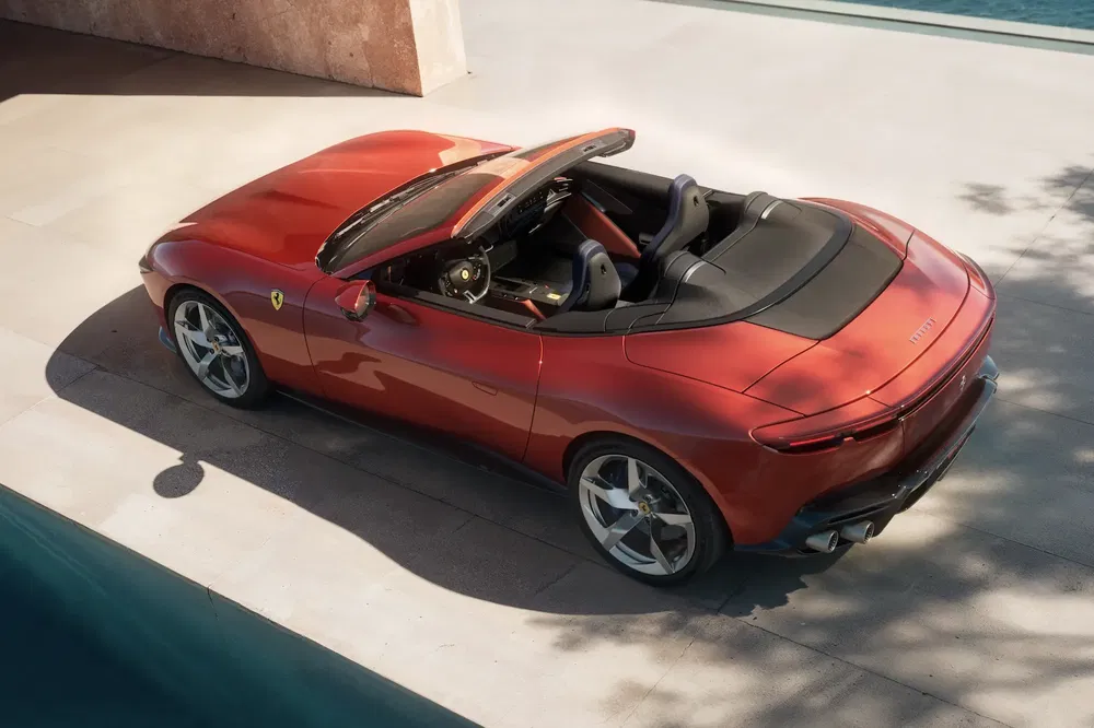 {"fr":"Ferrari Roma Spider rouge garée près d'une piscine, toit abaissé, design élégant et sportif.","nl":"Rode Ferrari Roma Spider geparkeerd bij zwembad, dak omlaag, elegant en sportief ontwerp."}