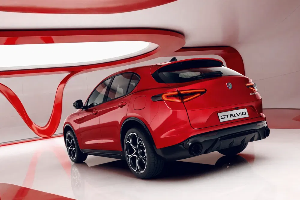 SUV Alfa Romeo Stelvio rouge dans un intérieur futuriste aux courbes rouges et blanches.