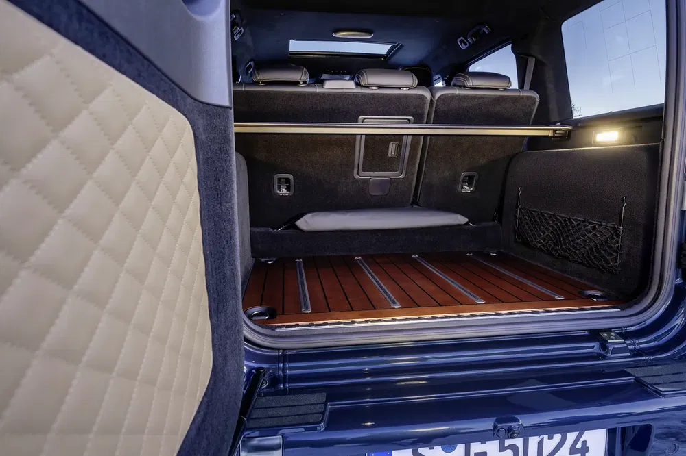 Kofferbak van de Mercedes-Benz G-Klasse met houten vloer en gewatteerd lederen interieur.