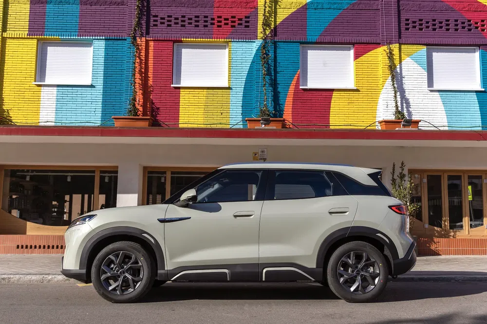 SUV Opel Mokka blanc stationné devant un mur coloré à motifs géométriques.