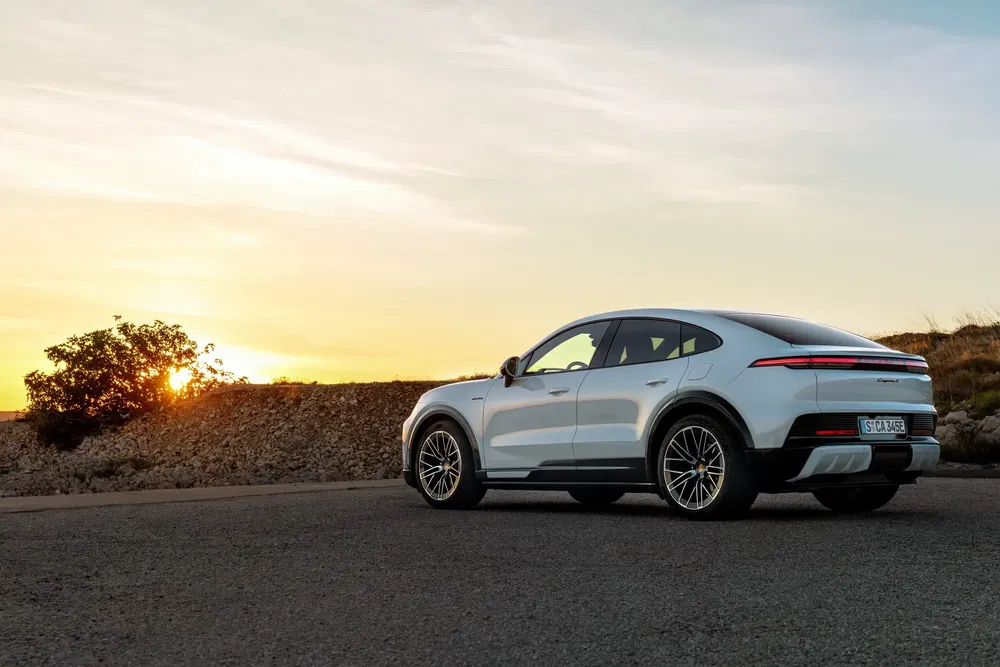 Witte Porsche Taycan bij zonsondergang, strak en modern design.