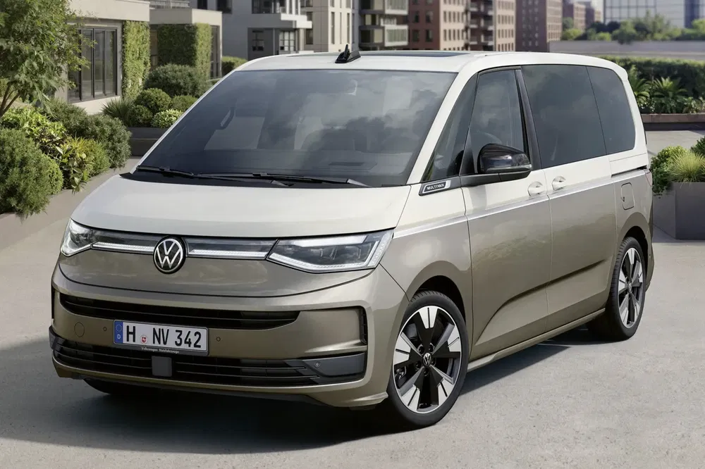 Volkswagen ID. Buzz 2023 beige sur une avenue urbaine moderne.