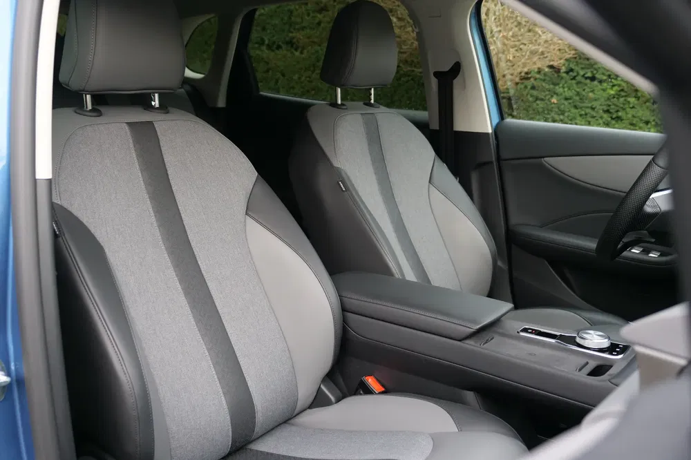 Intérieur Peugeot 208 avec sièges en tissu gris et tableau de bord moderne.