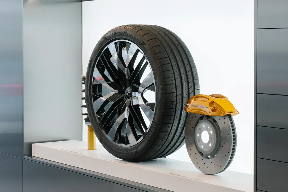 Roue et système de freinage d'une Porsche Taycan exposés, détails du pneu et étrier jaune.