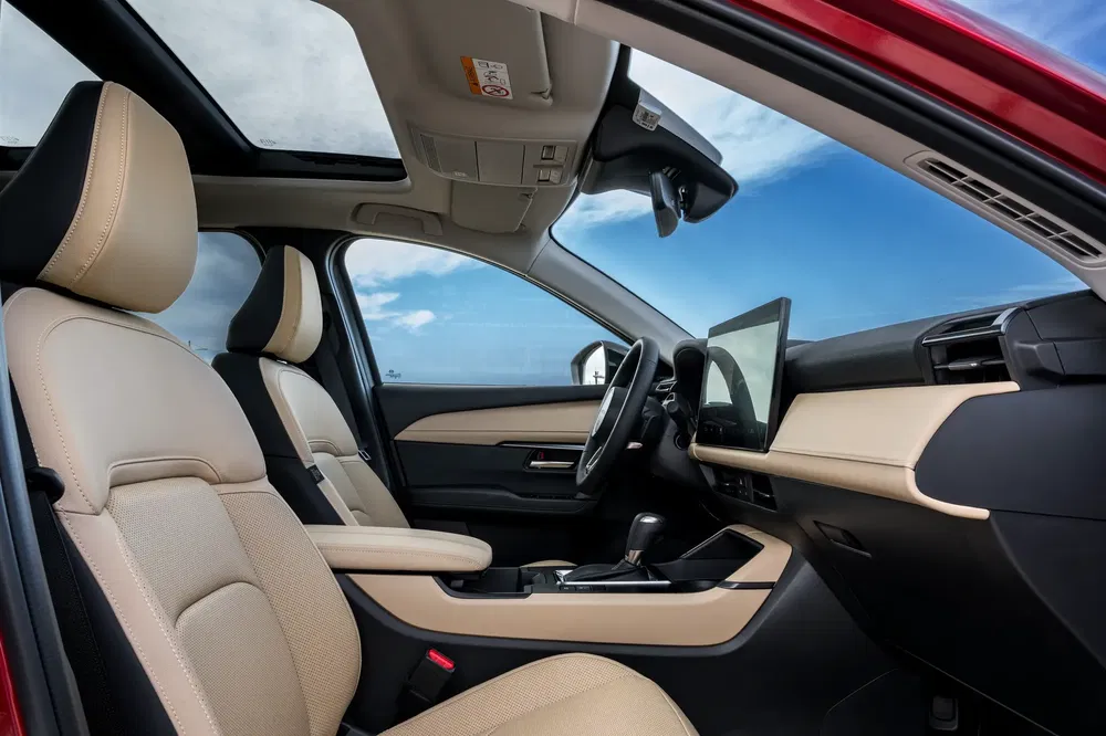 Ruim en modern interieur van een SUV met beige leder en panoramisch schuifdak.