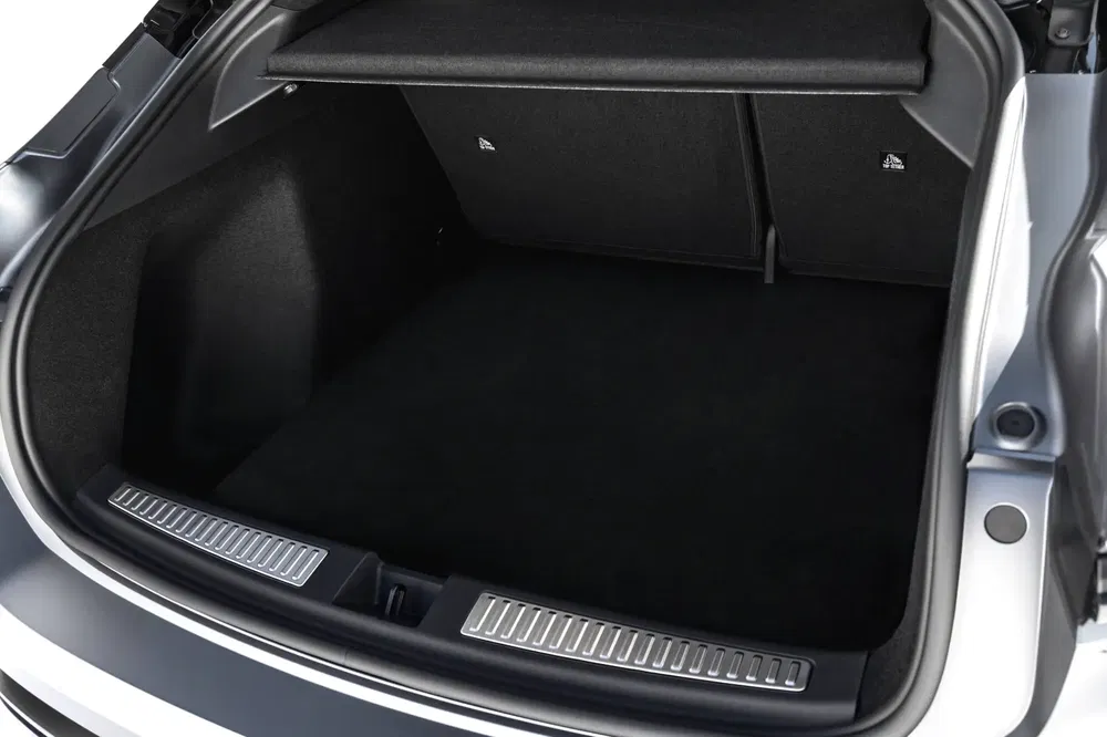 Coffre spacieux d'une voiture moderne avec finition intérieure noire élégante.