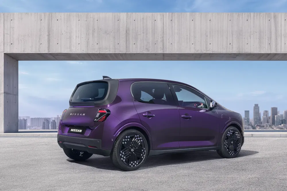 Nissan compacte violette moderne stationnée, vue arrière, avec arrière-plan urbain.