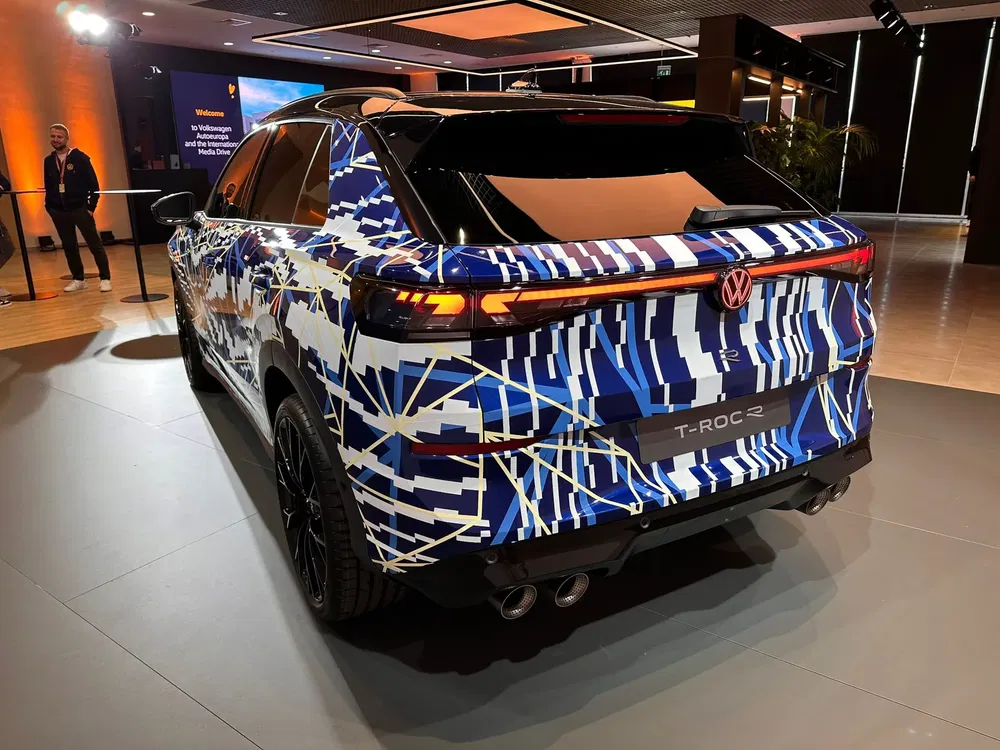 Volkswagen T-Roc 2 met camouflagepatroon in een helder verlichte showroom.