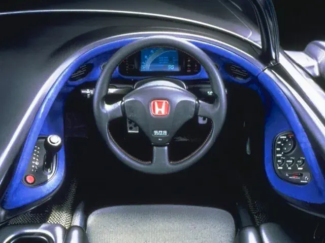 Intérieur futuriste de la Honda FSX avec tableau de bord numérique et volant ergonomique.