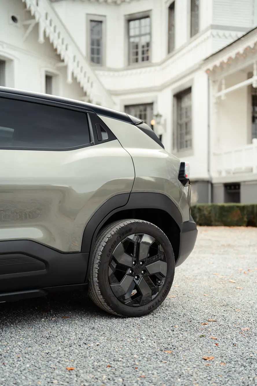 Achterzijde van een Toyota SUV in een grindoprit voor een wit herenhuis.