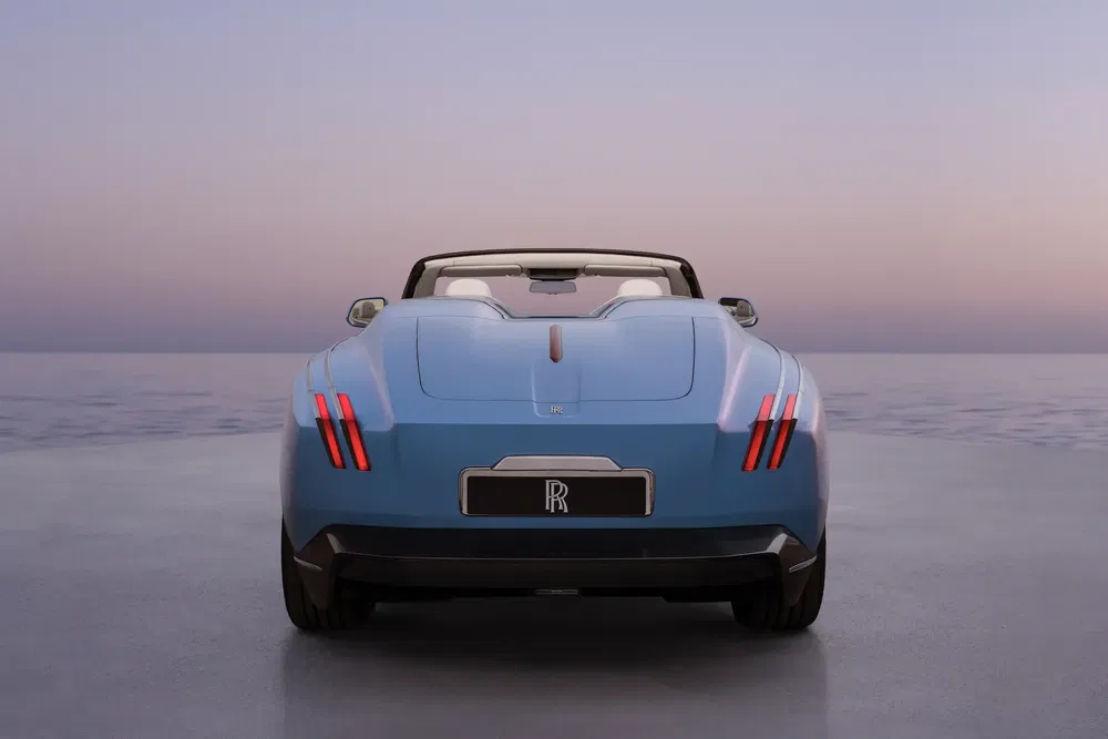 {"fr":"Rolls-Royce décapotable bleue, vue arrière, sur fond de coucher de soleil paisible.","nl":"Achteraanzicht van blauwe Rolls-Royce cabriolet tegen een serene zonsondergang."}