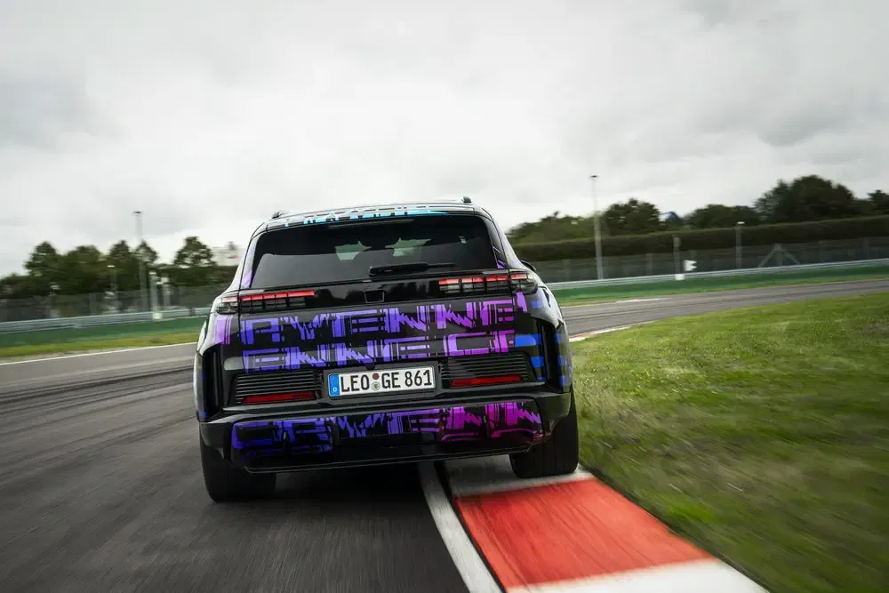 Porsche Cayenne SUV racet door een bocht op het circuit, toont prestaties en wendbaarheid.