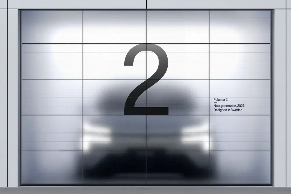 Prototype flou de la Polestar 2 derrière une porte avec grand numéro '2'.