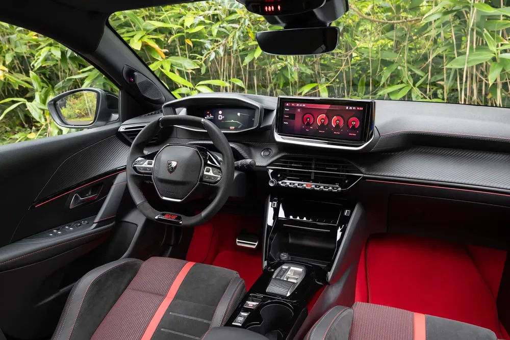 Intérieur moderne d'une Peugeot équipée de tableaux de bord numériques et volant sport.