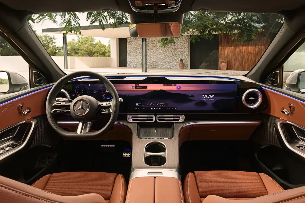 Moderne interieur van een Mercedes met elegant digitaal dashboard en kenmerkend stuurwiel.