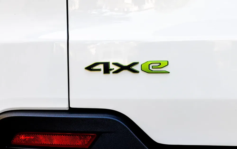 Écusson 4xe vert sur carrosserie arrière d'une voiture Jeep blanche.