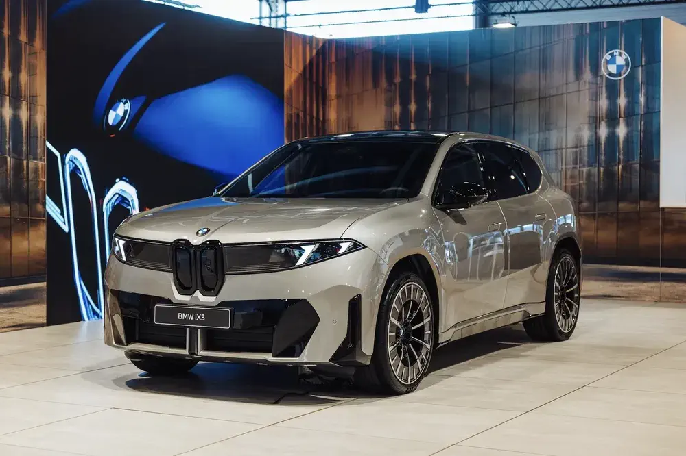 BMW iX3 électrique exposé dans un showroom moderne, design élégant et lignes sportives.