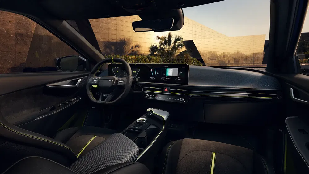 Intérieur de la Kia EV6 avec tableau de bord numérique moderne et accents verts.