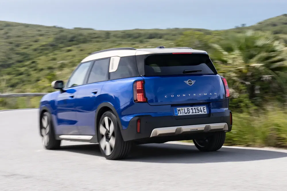 {"fr":"MINI Countryman bleu sur route sinueuse avec paysage verdoyant.","nl":"Blauwe MINI Countryman op kronkelige weg met groene omgeving."}