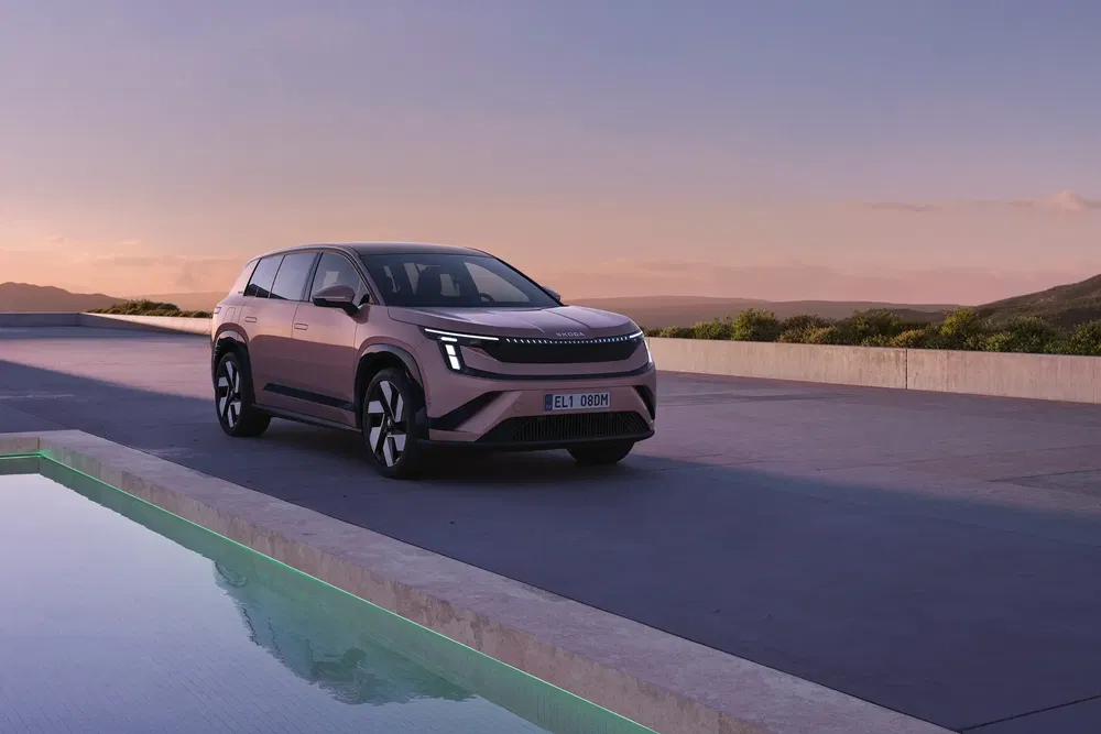 Renault Scenic électrique au crépuscule avec paysage de montagne en arrière-plan.
