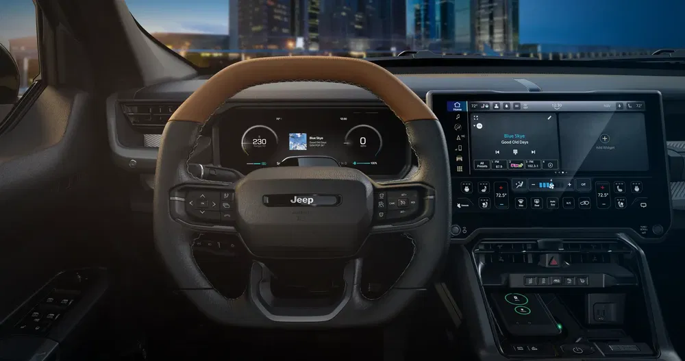 Interieurdashboard van een Jeep met touchscreen en modern stuur.