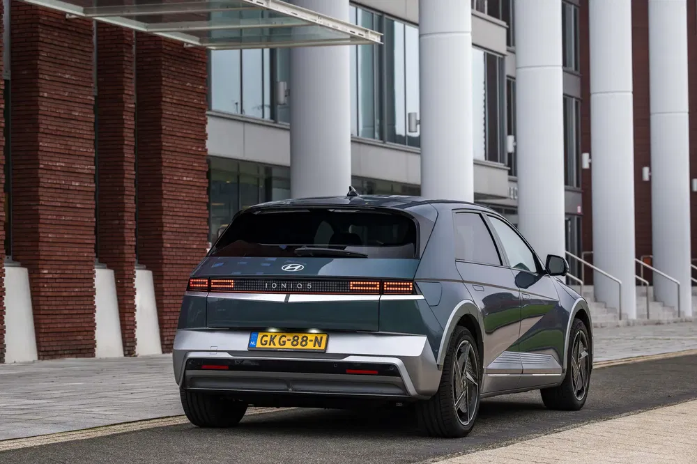 Hyundai Ioniq 5 stationné devant un bâtiment moderne, design futuriste et élégant.