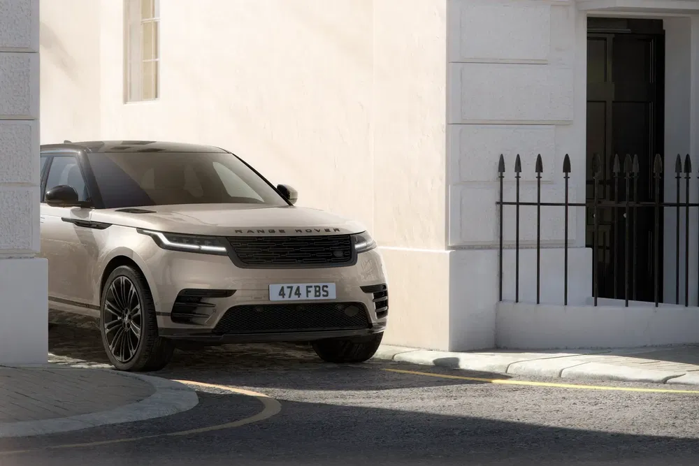 {"fr":"Range Rover Velar stationné dans une rue étroite, design moderne et élégant.","nl":"Range Rover Velar geparkeerd in een smalle straat, modern en elegant ontwerp."}