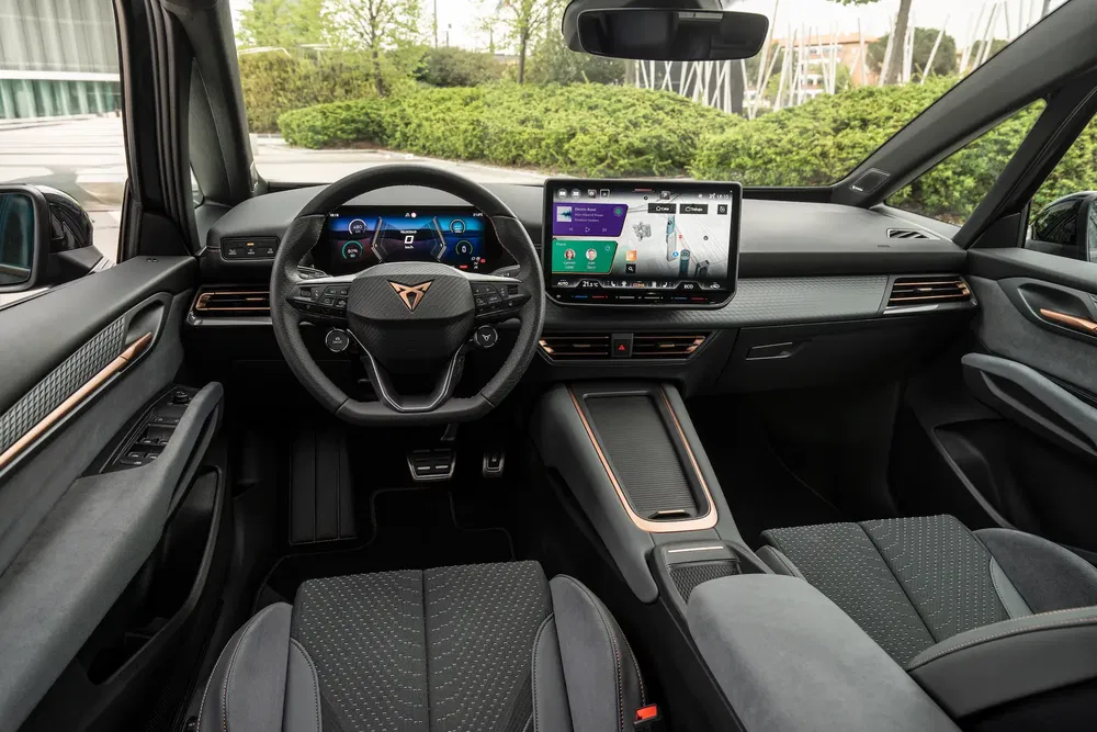 Intérieur moderne de la Cupra Tavascan avec écran tactile central et volant numérisé.