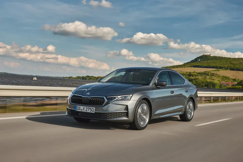 Škoda Octavia sur une route dégagée, paysage rural en arrière-plan.