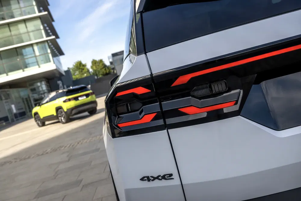 Hayon arrière d'un SUV 4xe blanc avec feux arrière modernes près d'un bâtiment urbain.