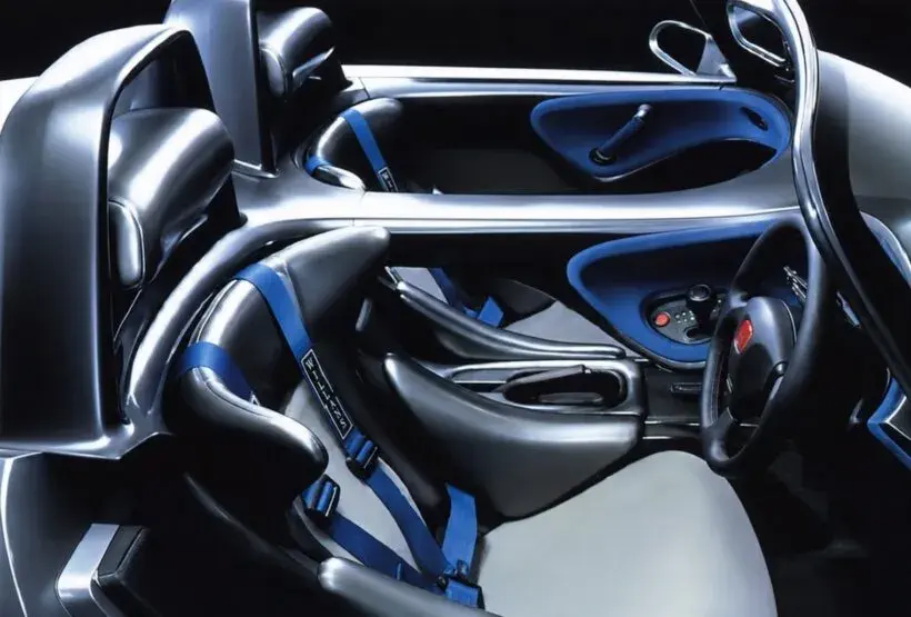 Intérieur futuriste de la Bugatti, sièges baquets et harnais bleus, design sportif et élégant.