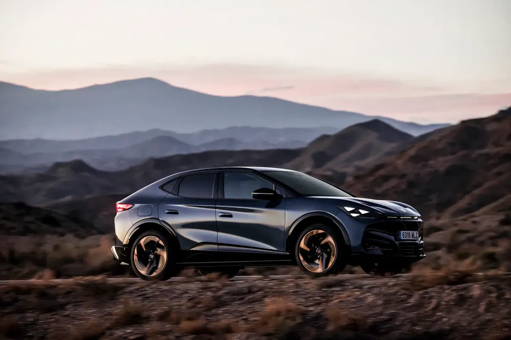 Moderne Cupra Tavascan SUV tegen berglandschap bij schemering.