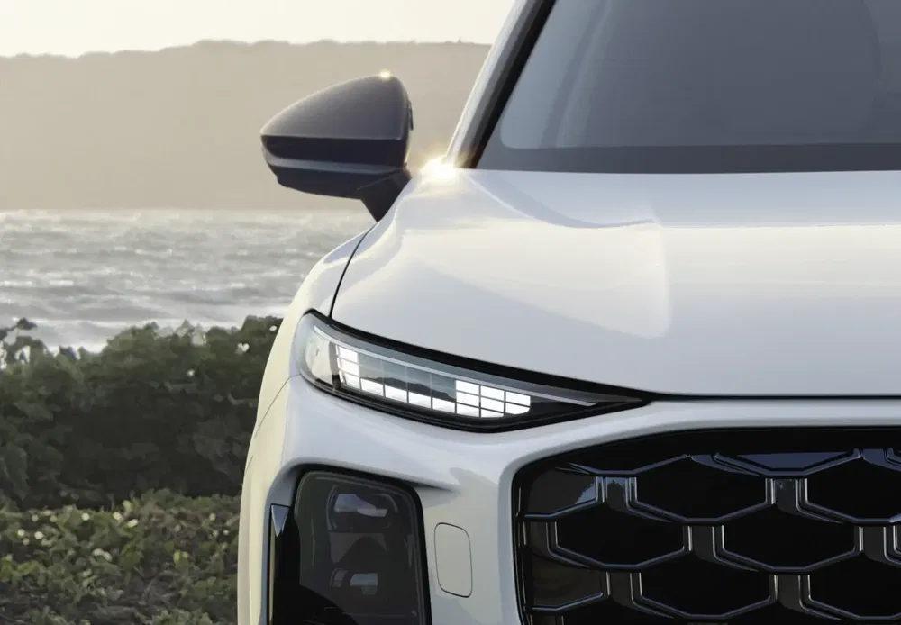 Avant de SUV moderne avec phares LED au bord de mer au crépuscule.