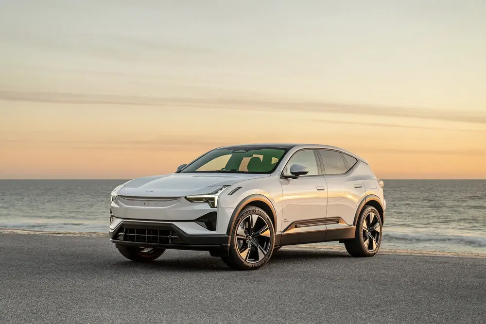 SUV Polestar 3 blanc garé près de la mer au coucher du soleil.