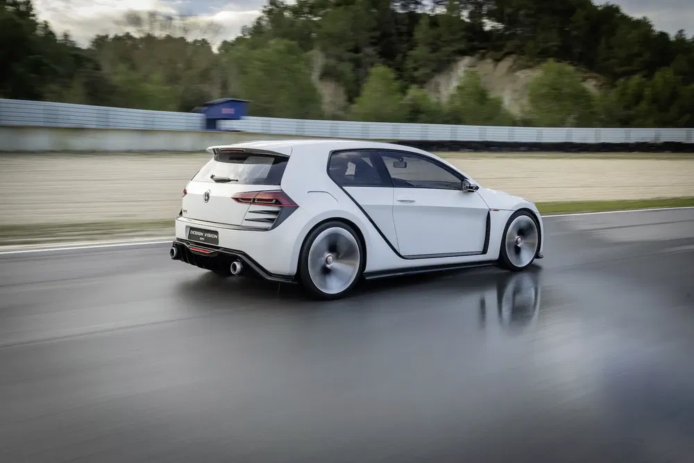 Volkswagen Golf GTI roulant sur circuit humide, arrière puissant et aérodynamique distinctif.