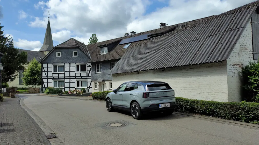 Polestar 2 électrique stationnée dans une rue de village pittoresque avec maisons traditionnelles.