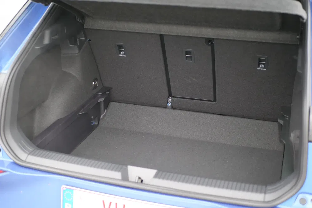 Ruime kofferbak van een blauwe auto met neerklapbare stoelen.