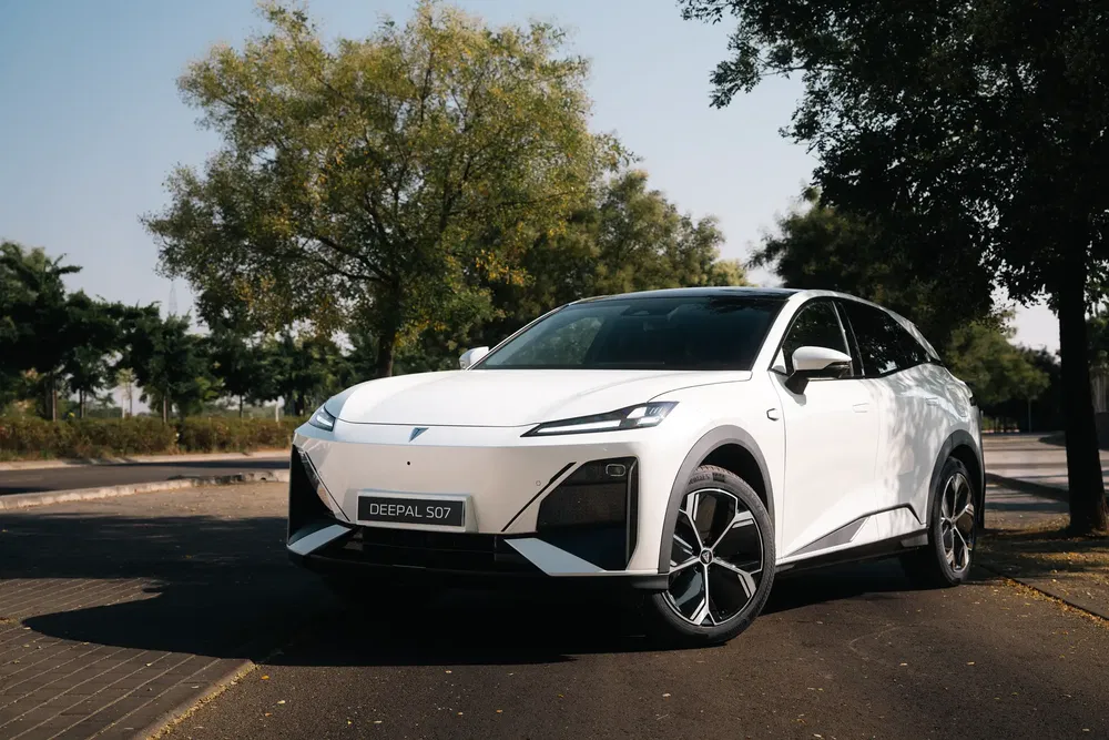 Voiture électrique Deepal S07 blanche garée sous des arbres, design moderne et aérodynamique.
