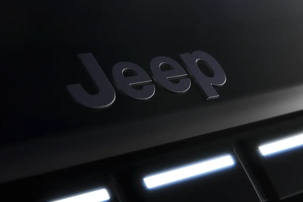 Jeep-logo op zwarte motorkap, subtiele LED-verlichting op achtergrond.