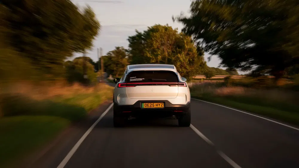 Polestar 2 électrique blanche sur une route de campagne au coucher du soleil.