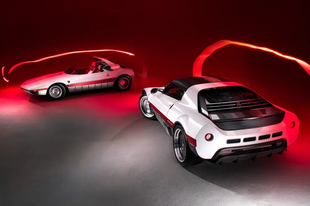 Twee witte sportwagens onder dynamische rode verlichting in een moderne studio.